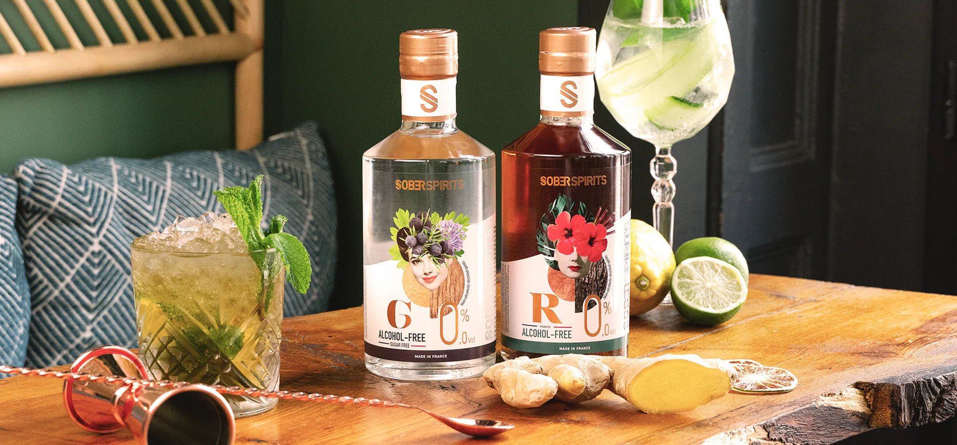 Zwei Flaschen Sober Spirits alkoholfrei, umgeben von Cocktails, Limetten und Ingwer