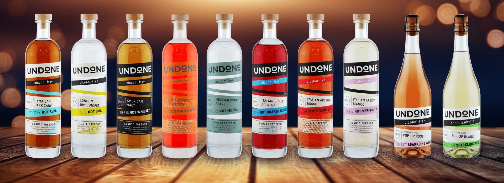 Eine Reihe von Undone alkoholfreien Spirituosen und Schaumweinen auf einem Holztisch