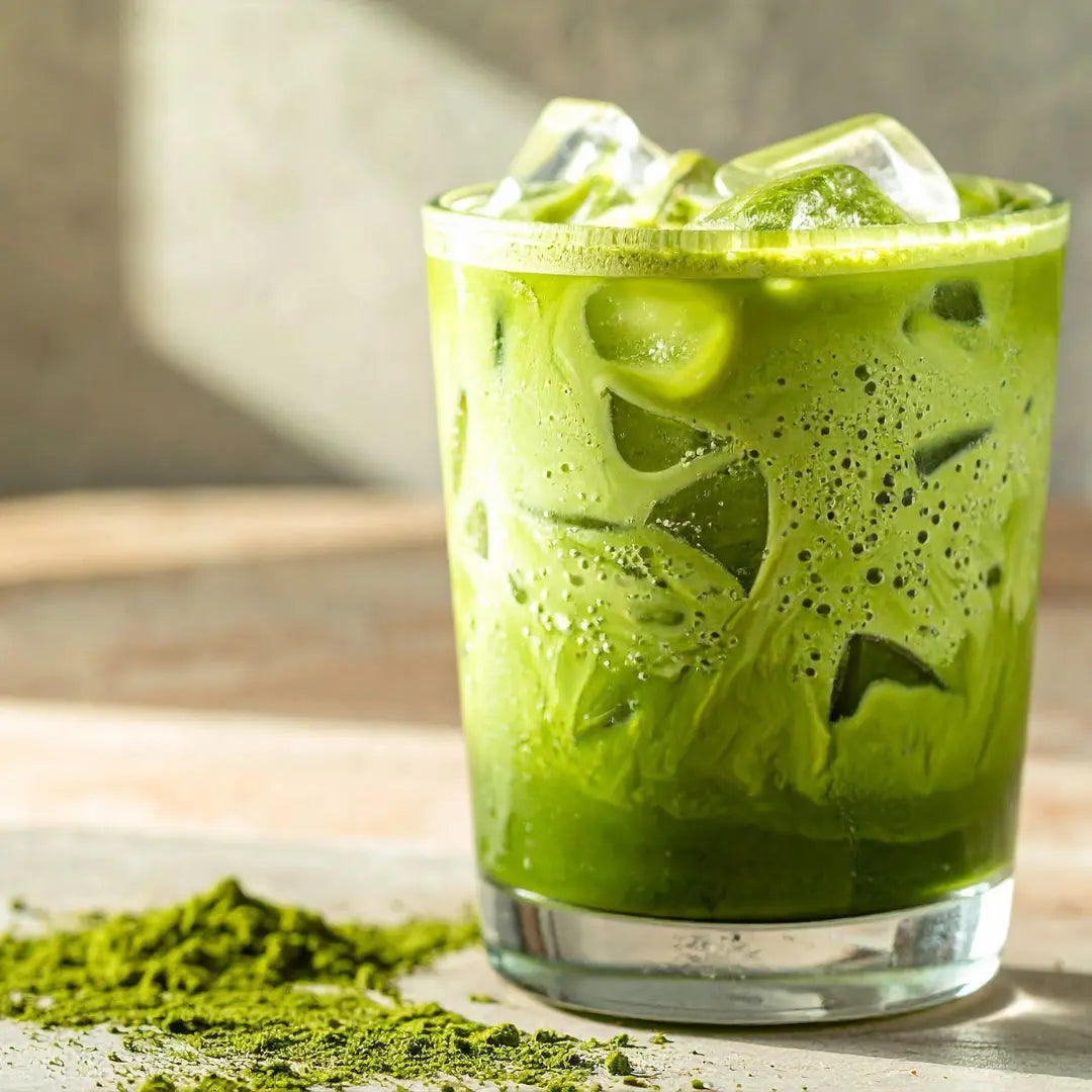 Alkoholfreier Matcha Mocktail mit Eiswürfeln und frischer Minze im Glas auf hellem Hintergrund