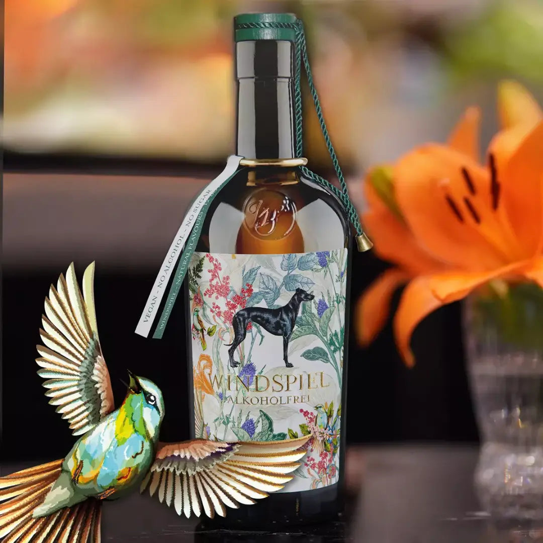 Windspiel Botanicals Flasche mit Glas auf einem Tisch arrangiert