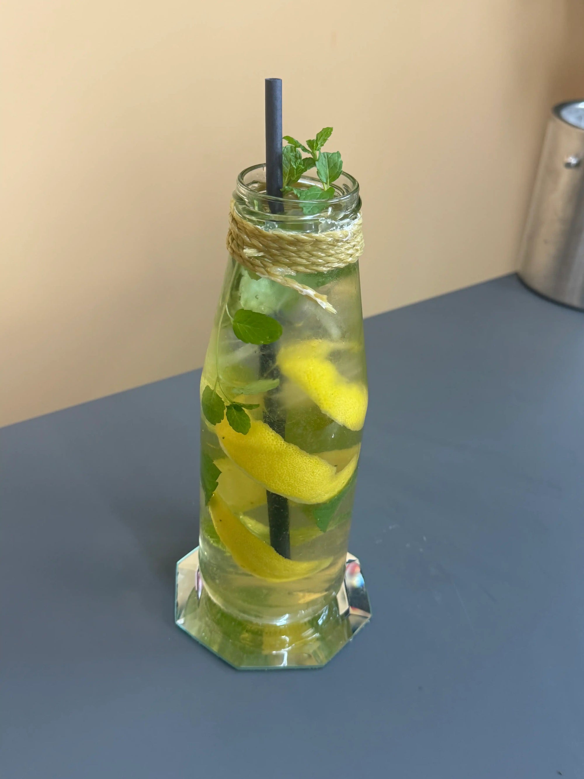 Alkoholfreie Zitronenbowle mit Minze und Eis in einer dekorativen Flasche